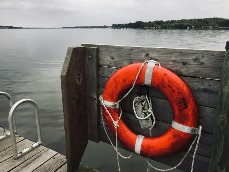 life raft tied to a wooden dock by water