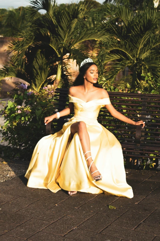 a woman dressed in a yellow dress is on a bench