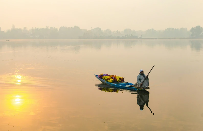 a man sitting in a small boat on the water