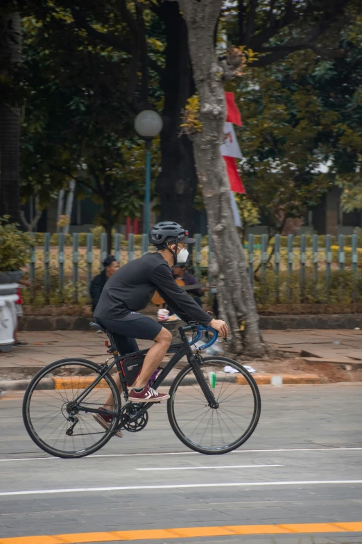 two men wearing helmets ride their bikes on the street