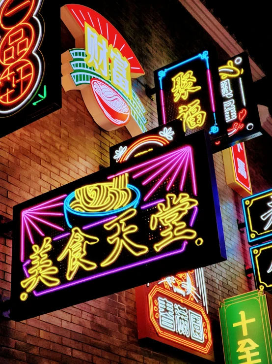 many different lit up signs on a building