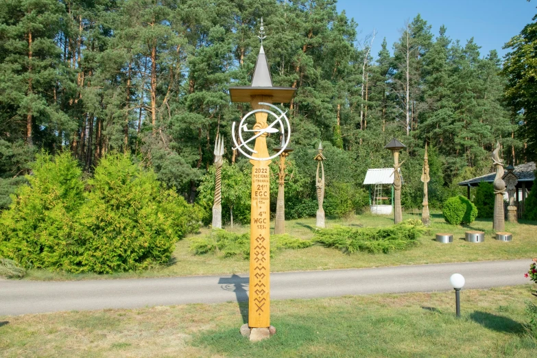 a giant wooden clock on the side of the road