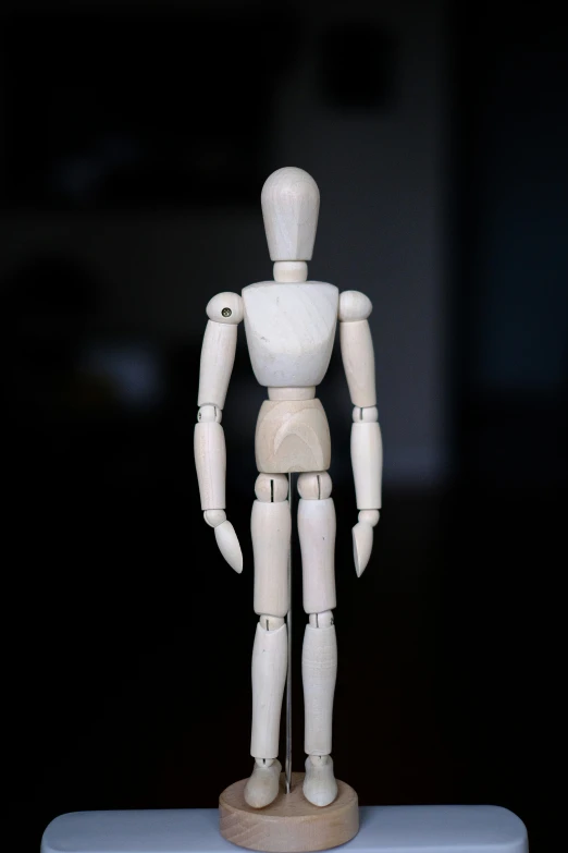 an unfinished doll stands upright on a plastic tray