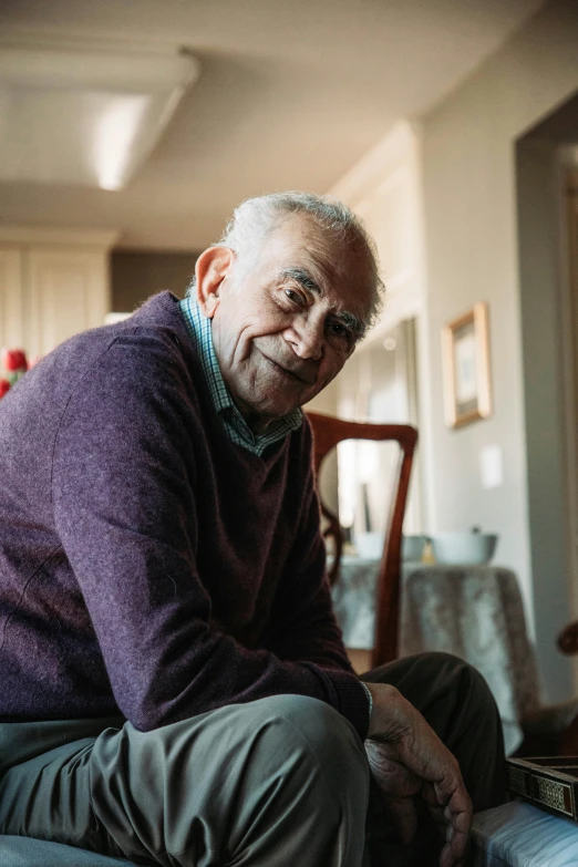 a man is smiling while sitting on a couch