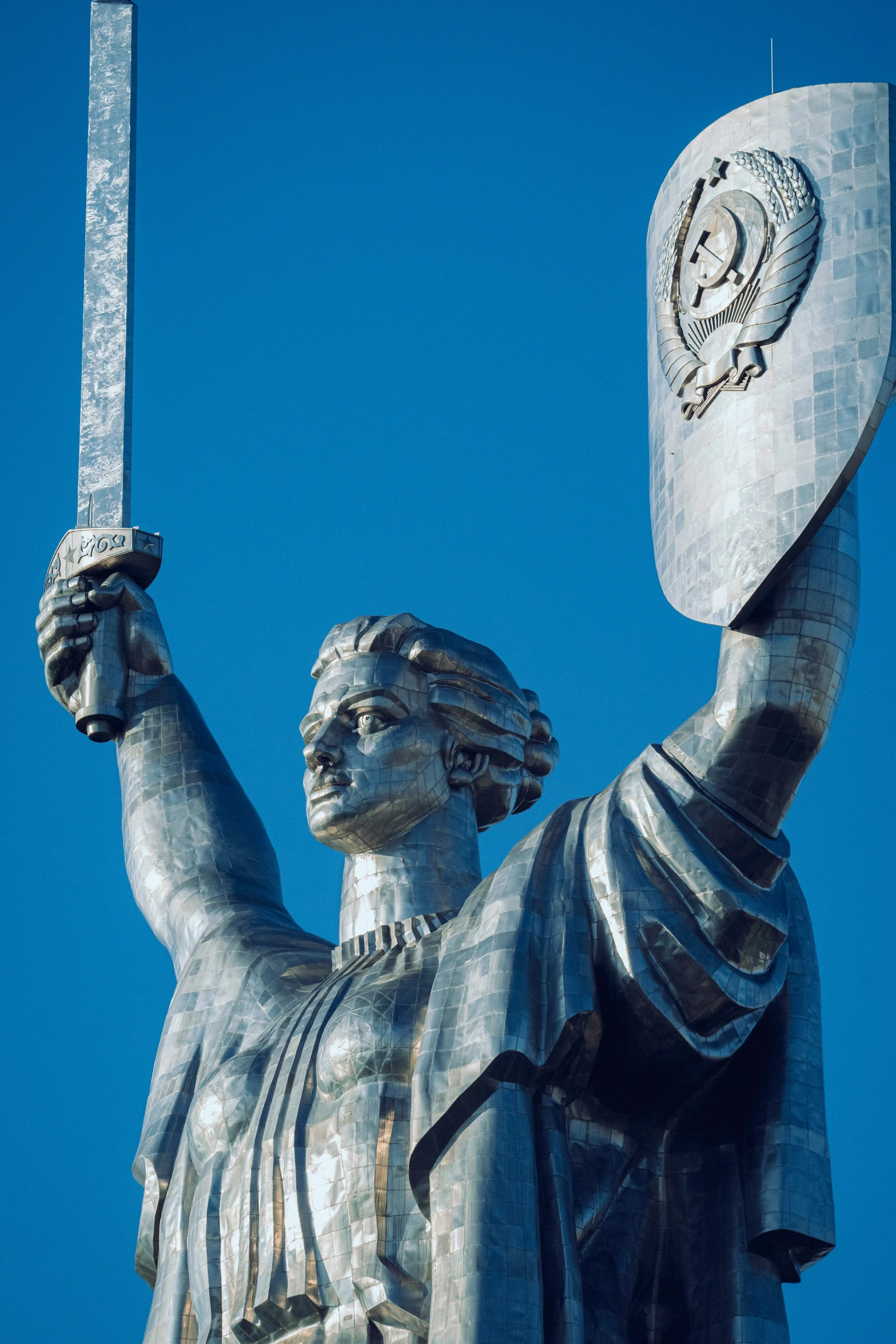 the statue shows the flag and is holding up a sword