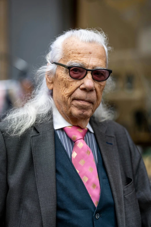 an old man with long white hair in a suit and tie