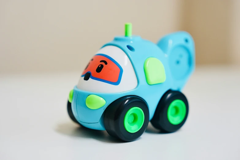 blue and green toy car on white surface