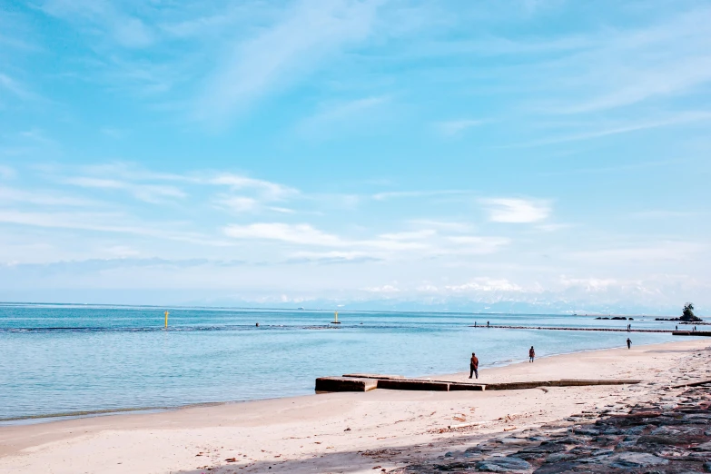 the sandy shore of an ocean with a small dock