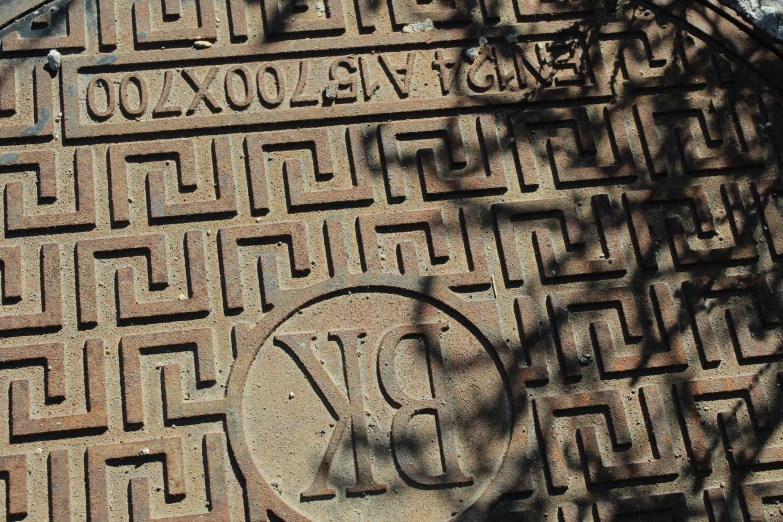 a stone wall is decorated with a manhole