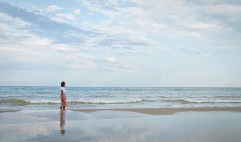 a person is walking on the beach in the ocean water