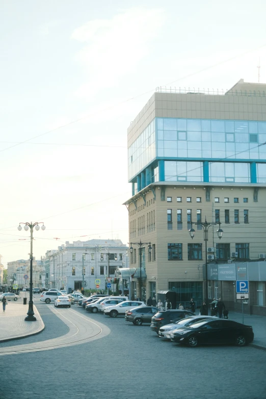 an intersection in front of buildings and parked cars