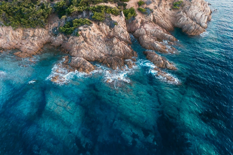 the aerial view of an island in the ocean with lots of water