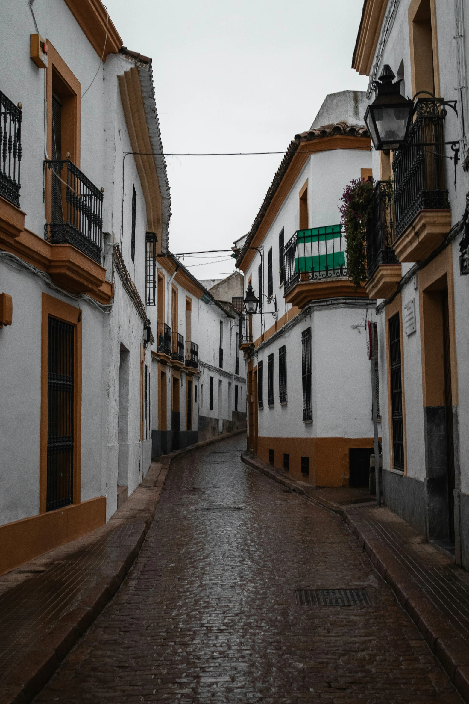 narrow street in a neighborhood with yellow and white buildings