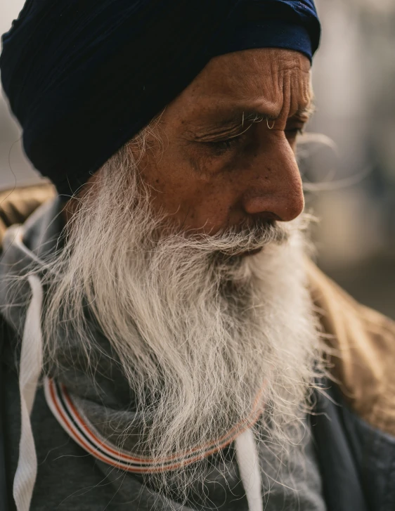 the man is wearing a black turban and standing outside