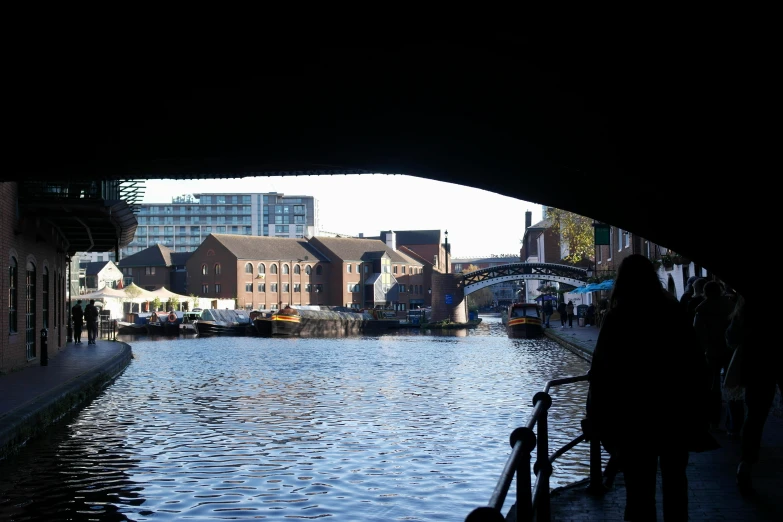 a group of people walking down a long canal