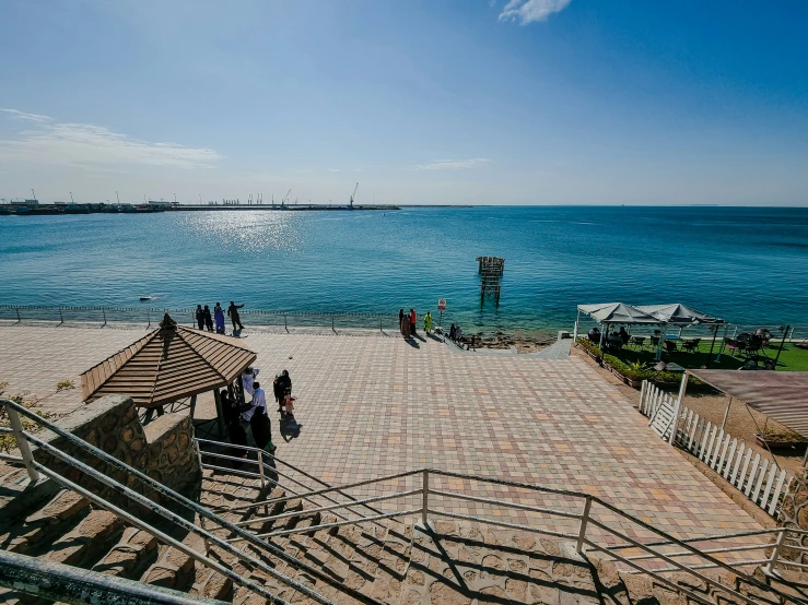 a sandy beach area with an open umbrella and stairs