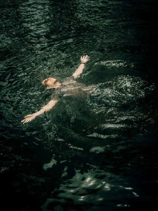 a woman swims in the water on her back