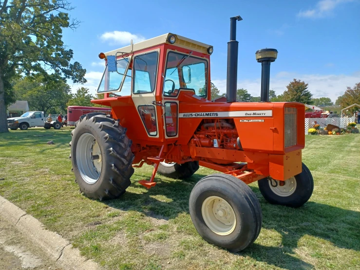 a red tractor is parked on some grass