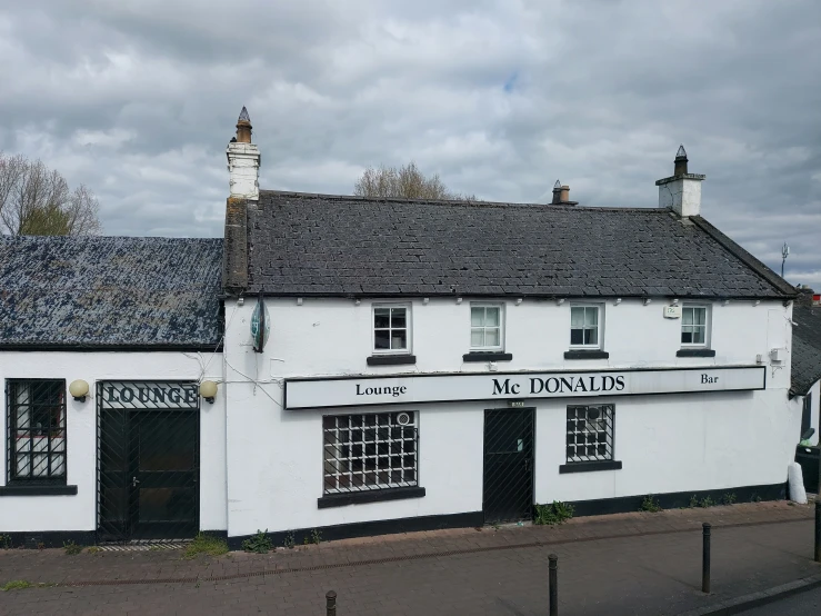 the pub is white with black trim and shingled windows