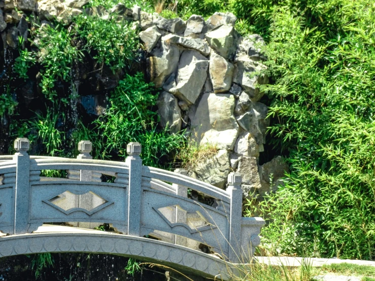 an empty bridge with stone walkways in the water