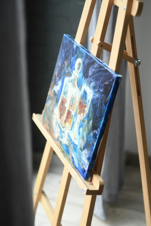 a miniature wooden ladder holding a painting