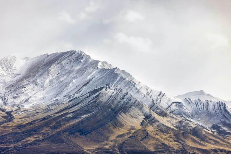 a snow covered mountains with a small group of clouds in the background