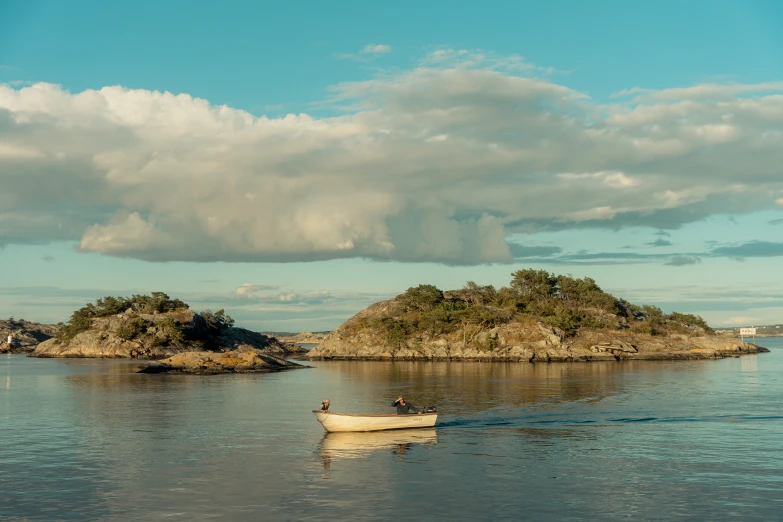 a small boat sails along a calm, sunny lake