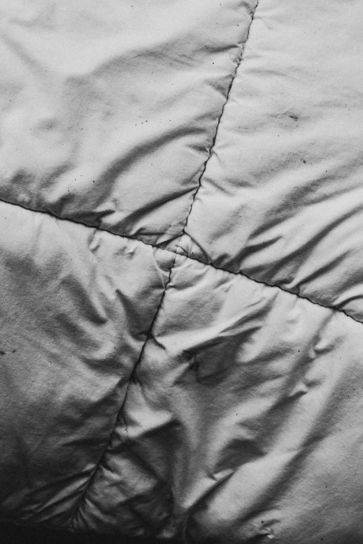 black and white image of an unmade comforter