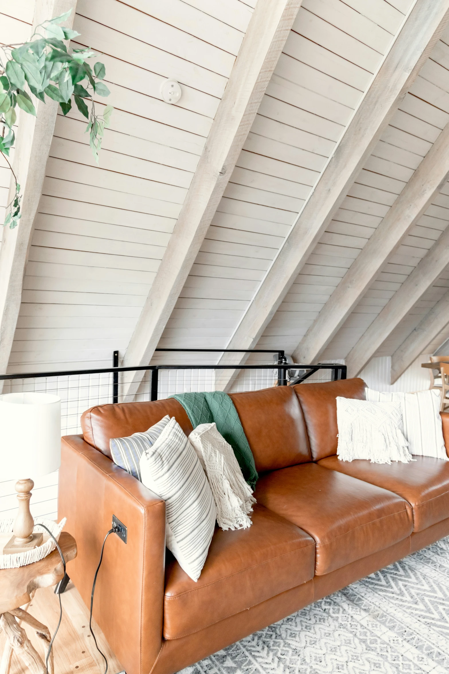 a leather sofa is sitting under a slanted ceiling