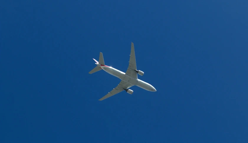a white jet plane in the blue sky