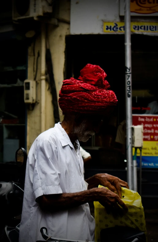 a man in a turban standing with a bag in hand