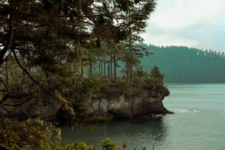 a boat is floating on the water near the cliff