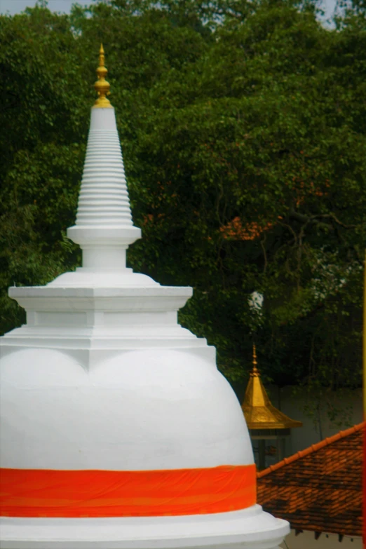 a white structure with gold on the top