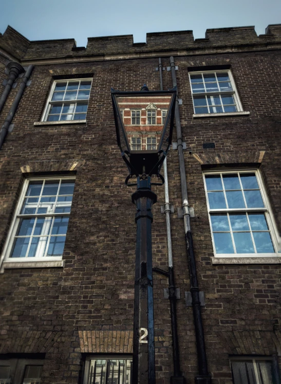 a lamp post outside an old brick building with many windows