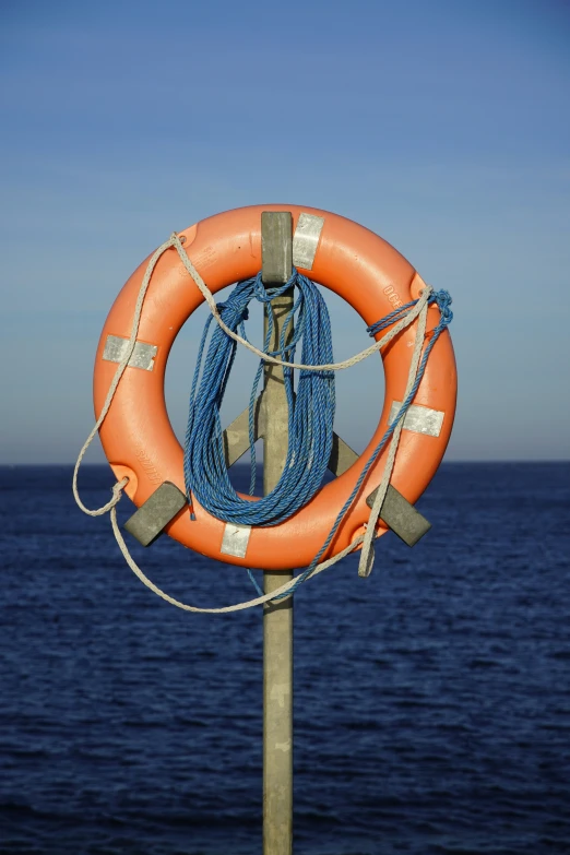 life ring tied to a pole by the sea