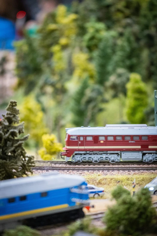 a red train on a train track next to bushes