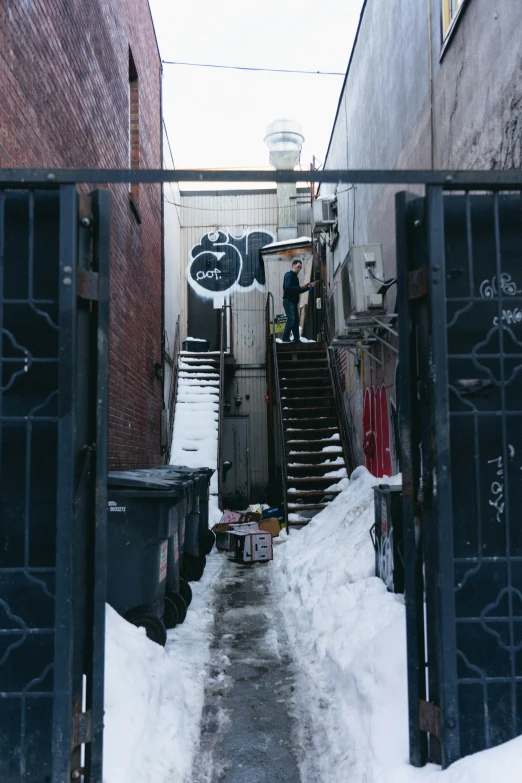 a narrow alley with a couple garbage cans