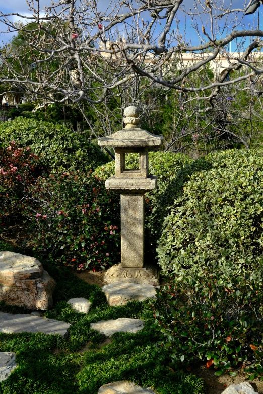 a small statue sits in the garden