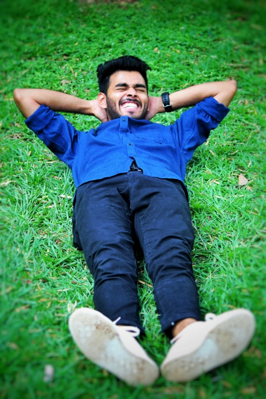 a man laying on the grass and smiling