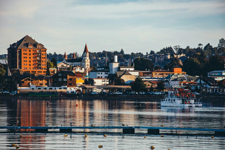 a fishing boat floats in a river while the city rises in the background