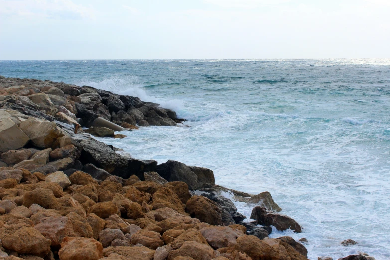 a rocky coastline near an ocean with waves