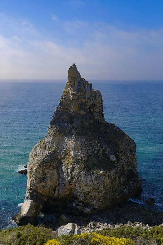 a very tall rock sticking out into the ocean