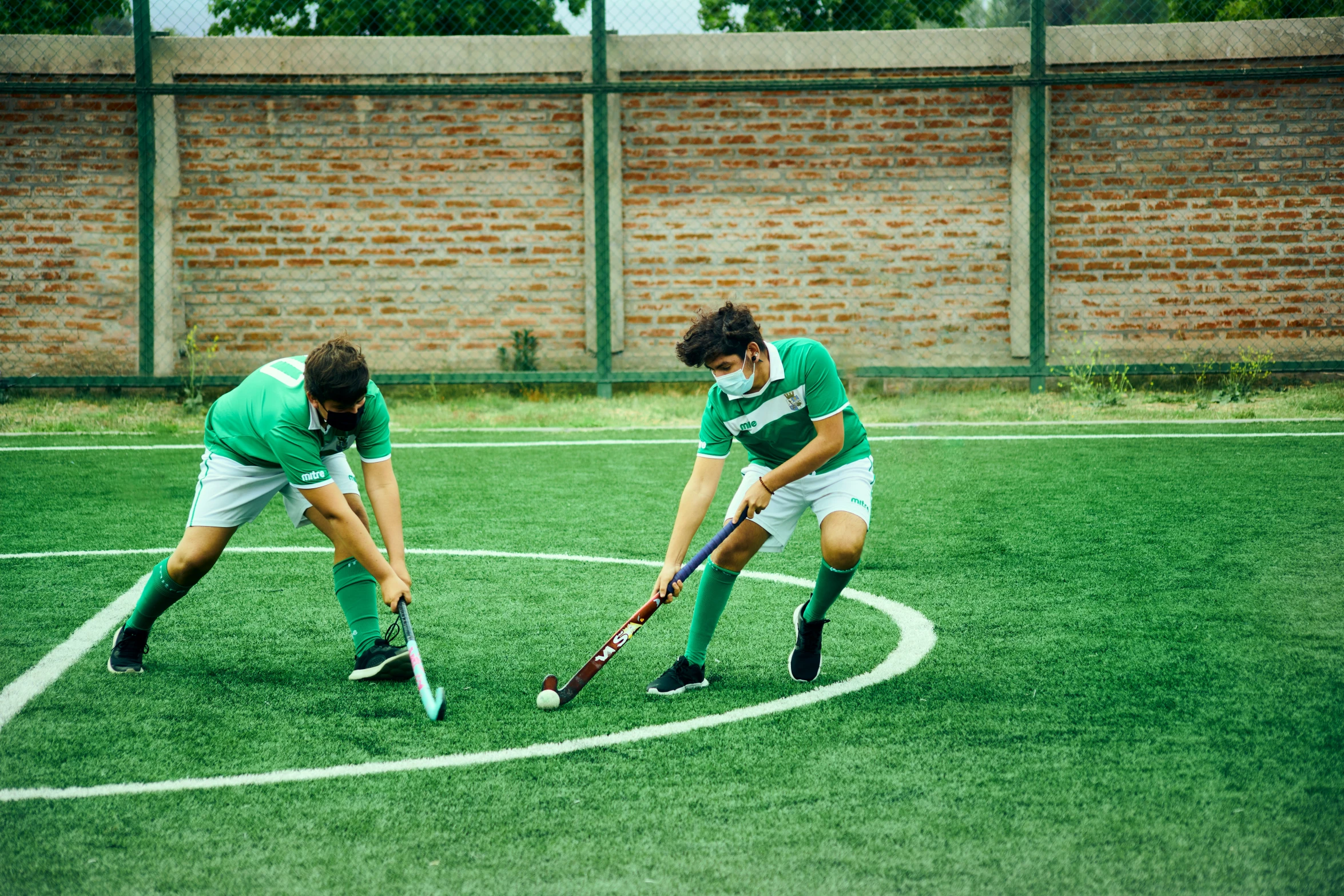 two children on a field playing field hockey