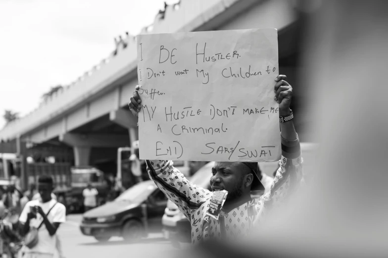 the man is protesting with his sign outside