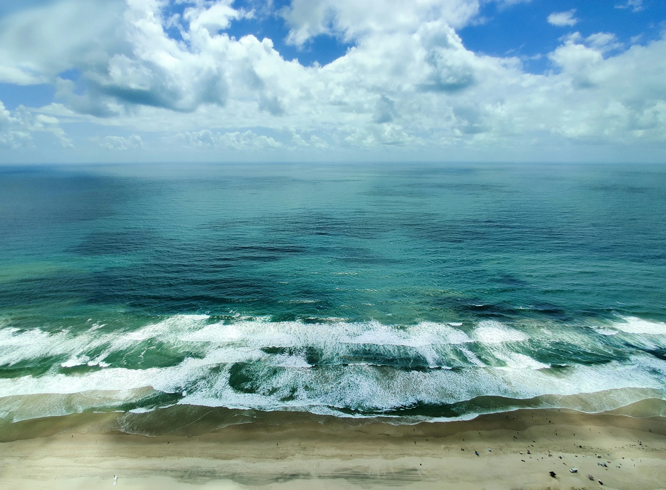 a view from a bird's - eye point of a shoreline on a partly cloudy day