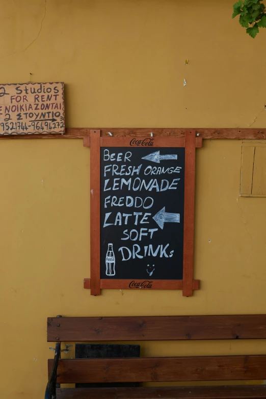 a sign hangs on the wall above a bench