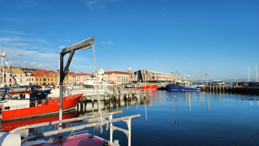 several red boats docked in a harbor with blue sky