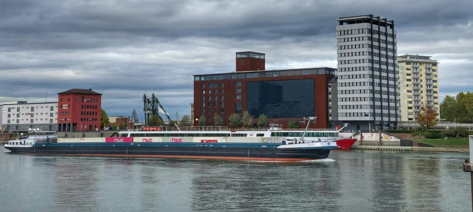 two boats floating on a river next to tall buildings