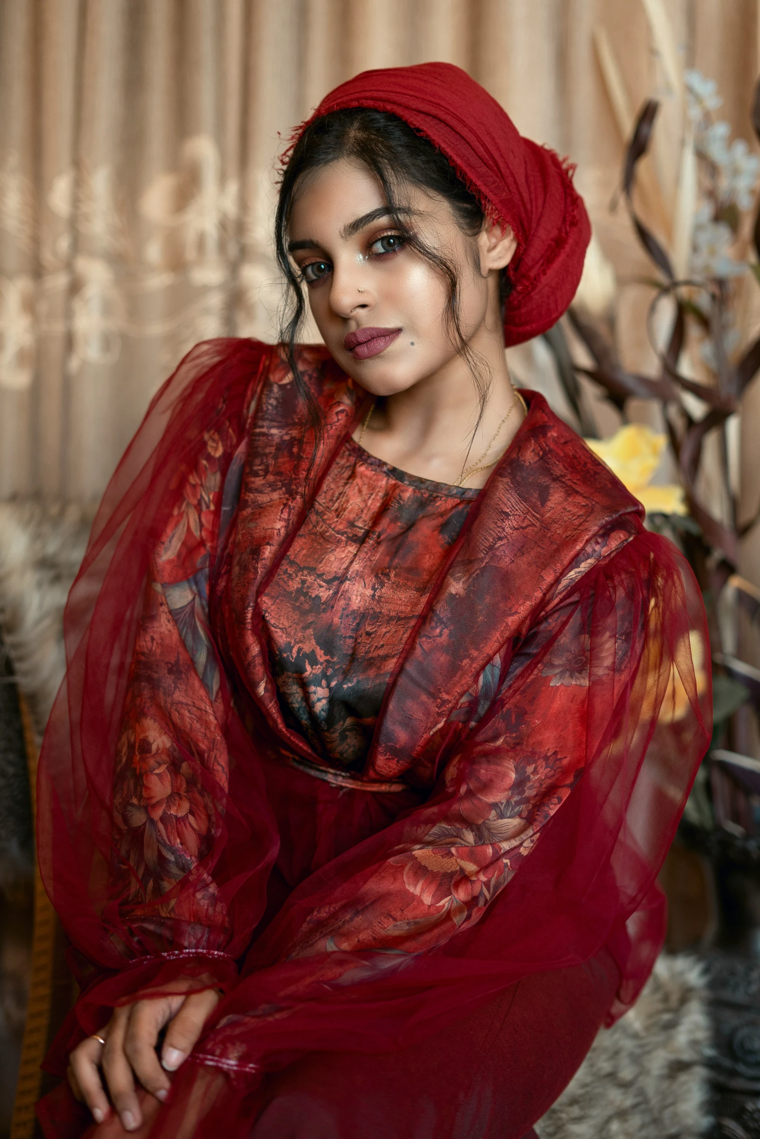 an indian woman posing for a picture wearing red