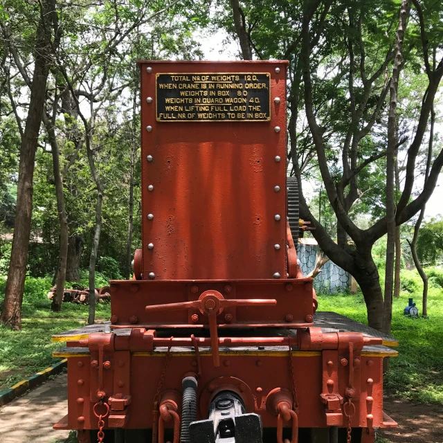 an antique red engine that is parked in the grass